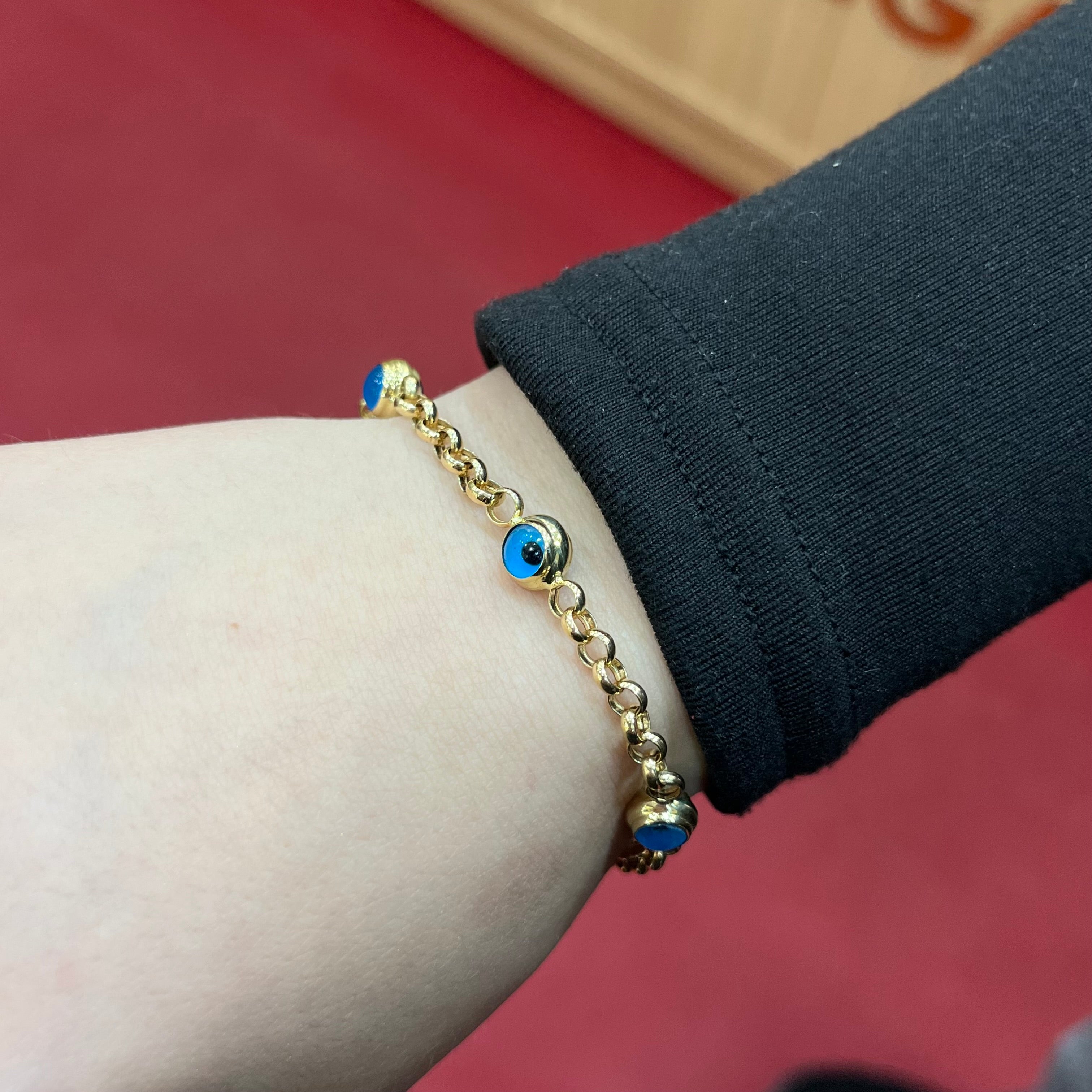 585 Nazarauge Kettenarmband aus 14 Karat Gelbgold mit mehreren blauen Schutzsymbolen am Handgelenk getragen