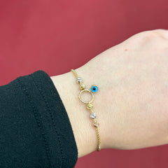 585 Nazarauge Armband aus 14 Karat Gelbgold mit Kugel-Elementen und blauem Schutzsymbol am Handgelenk getragen