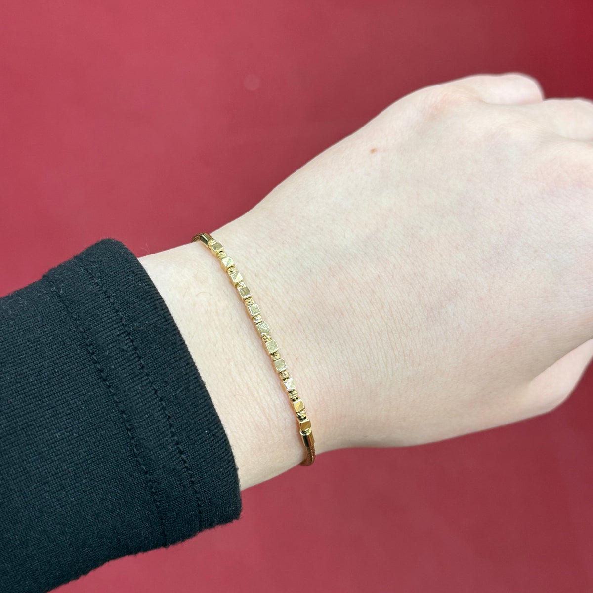 585 Dorika Cube Armband aus 14 Karat Gelbgold mit kubischen Gold-Elementen am Handgelenk getragen
