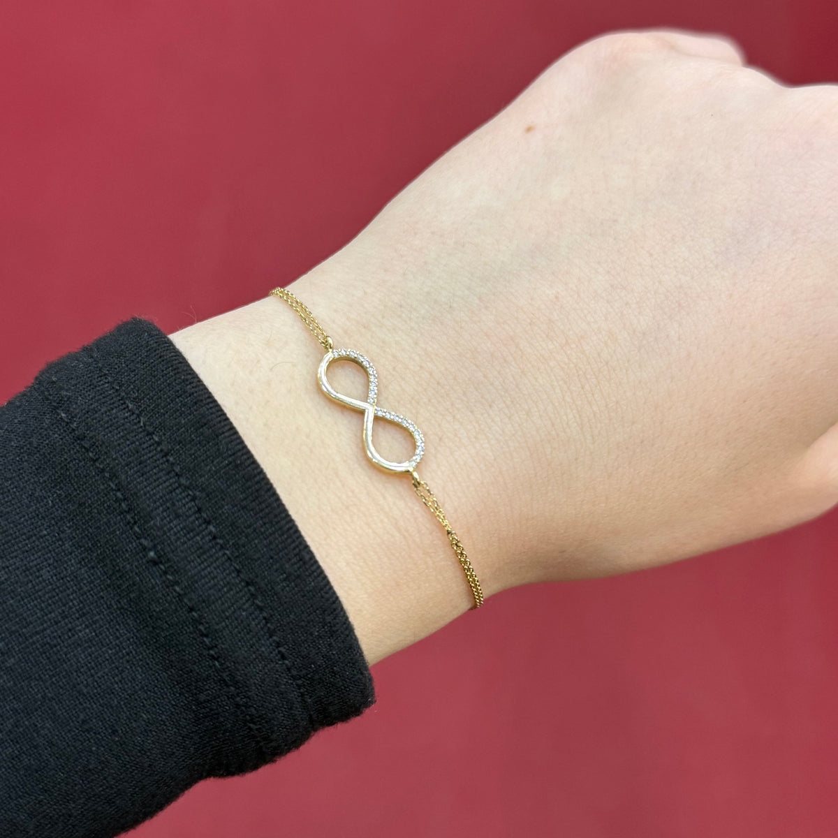 585 Infinity Armband aus 14 Karat Gelbgold mit Unendlichkeitssymbol am Handgelenk getragen