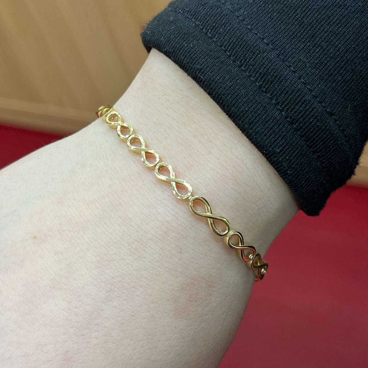 585 Infinity Kettenglieder Armband aus 14 Karat Gelbgold mit Unendlichkeitsmotiven am Handgelenk getragen
