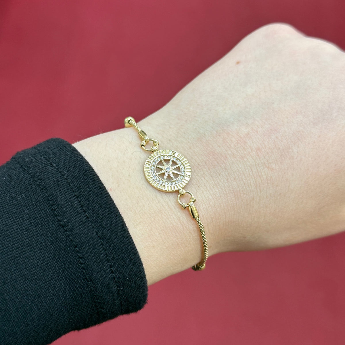 585 Kompass Armband aus 14 Karat Gelbgold mit Zirkonia und symbolischem Motiv am Handgelenk getragen