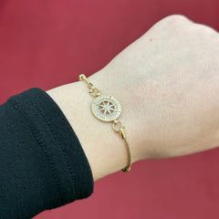 585 Kompass Armband aus 14 Karat Gelbgold mit Zirkonia und symbolischem Motiv am Handgelenk getragen