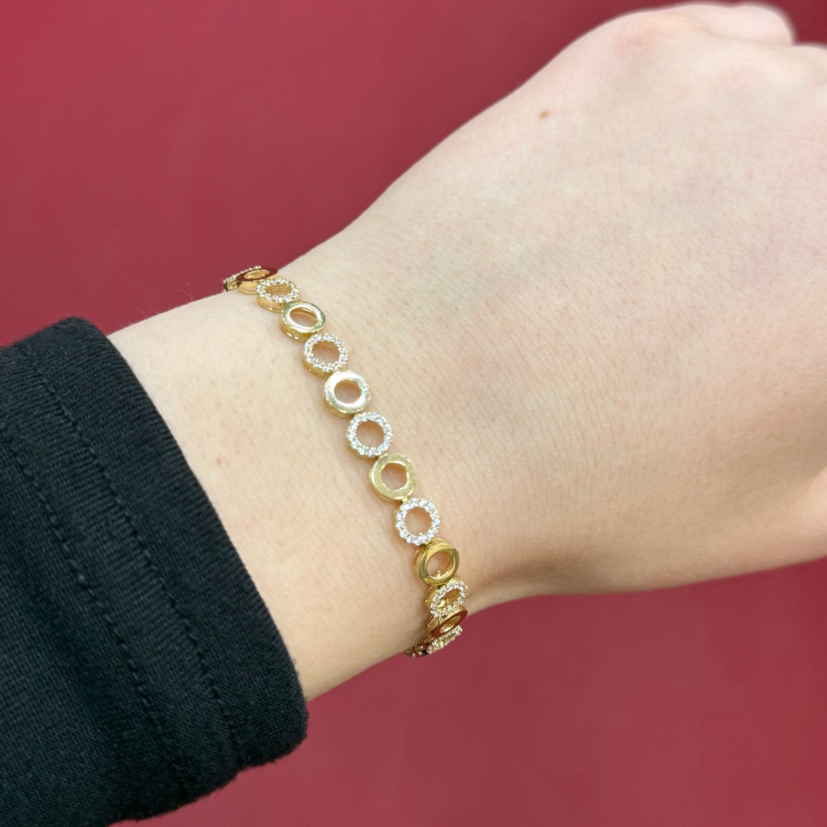 585 Zirkonia Armband aus 14 Karat Gelbgold mit runden Elementen und funkelnden Zirkonia-Steinen am Handgelenk getragen