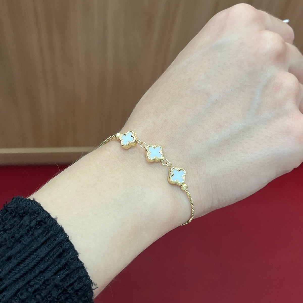 585 White Clover Armband aus 14K Gelbgold mit weißen Kleeblatt-Elementen am Handgelenk