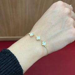 585 White Clover Armband aus 14K Gelbgold mit weißen Kleeblatt-Elementen am Handgelenk